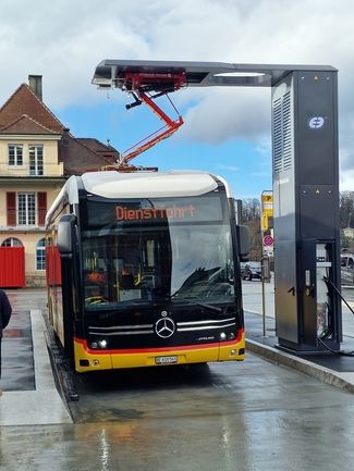 Postauto lädt an Pantographen in Spiez