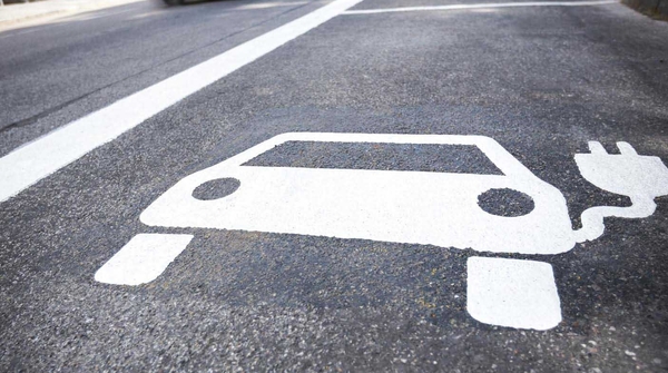 Weisse Strassenmarkierung eines EV-Ladeparkplatzes.