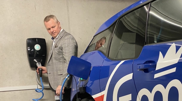 Ein Mann lädt ein Elektroauto mit einer Wallbox in einer Tiefgarage.