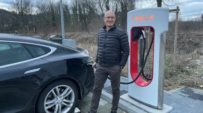 Peter Arnet lädt Elektrofahrzeug an Tesla-Ladestation