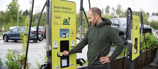 Mann scannt Karte an Ladestation